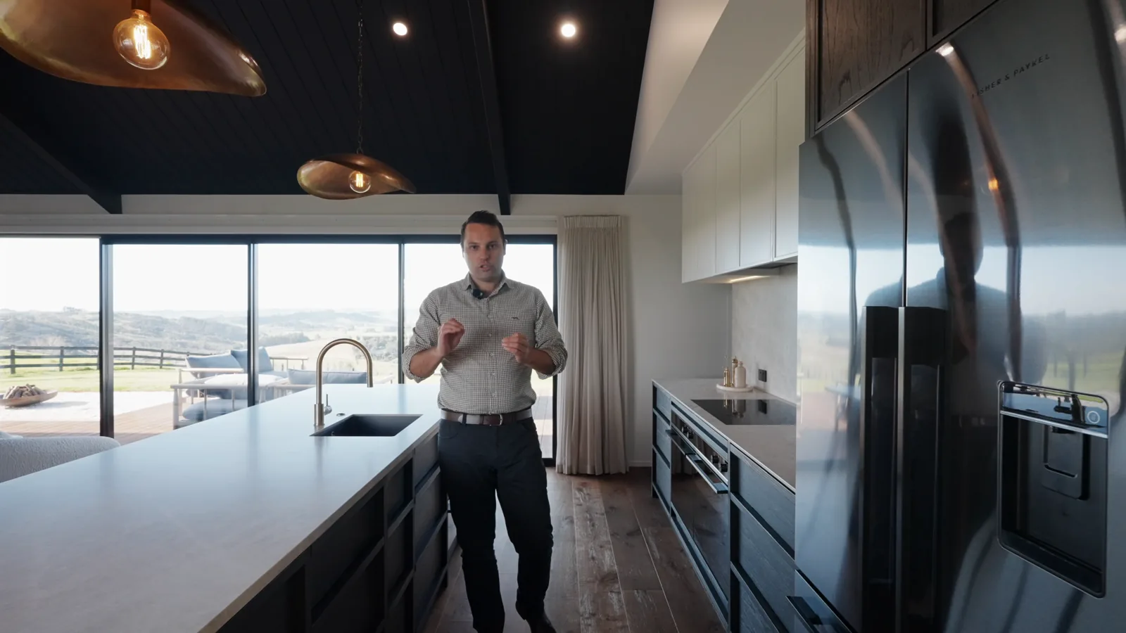 Trent from Arcline Architecture talking to camera in the kitchen of the modern black build, from our Dream Home Tour film