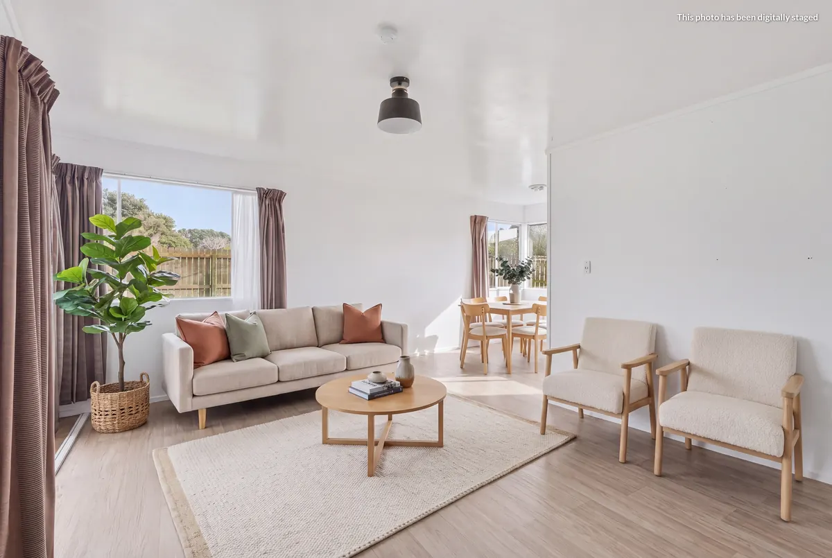 Staged lounge at 76 Takahe Road looking through to the dining area, with the digitally staged label top right