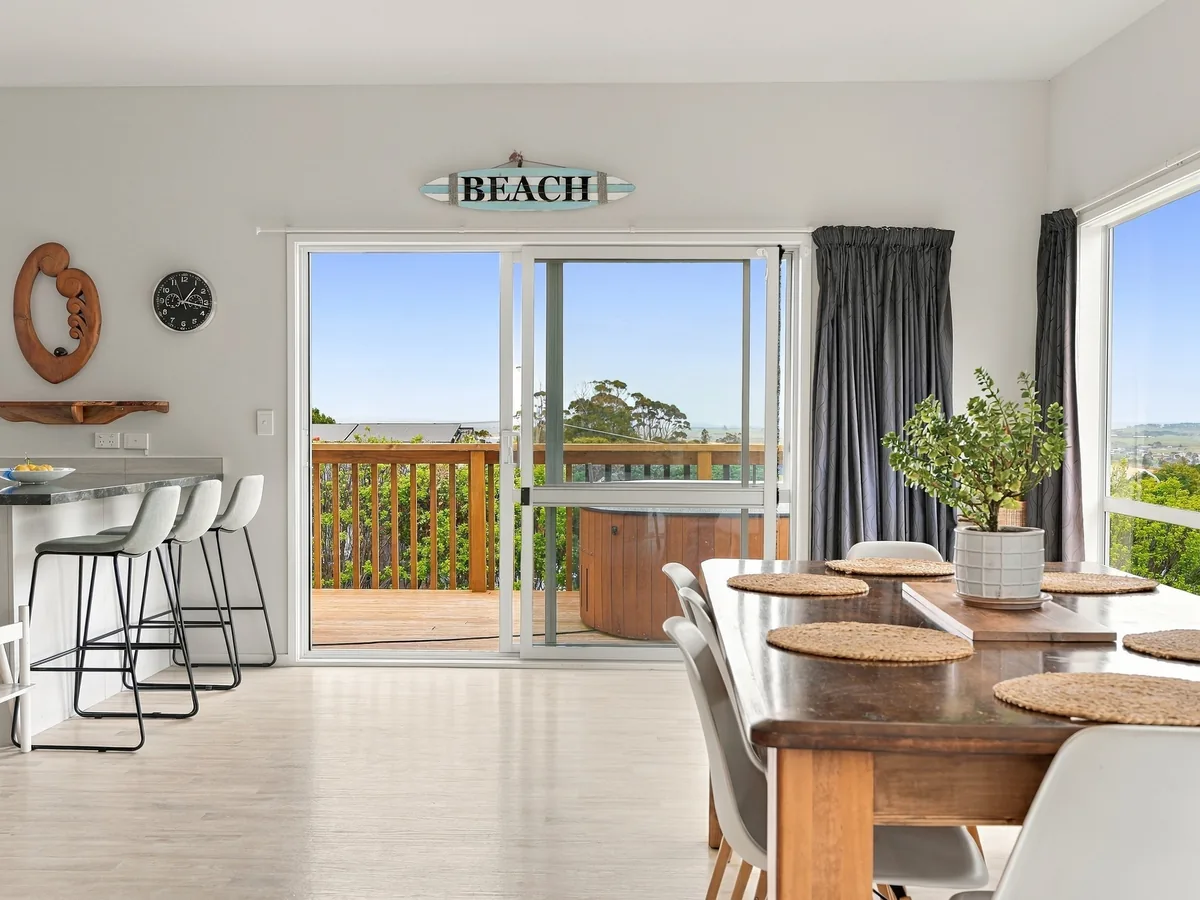 Open-plan dining room opening onto the deck at 4 Sunlover Way, Karikari Peninsula